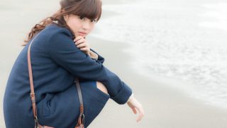 浜辺でしゃがむ女性