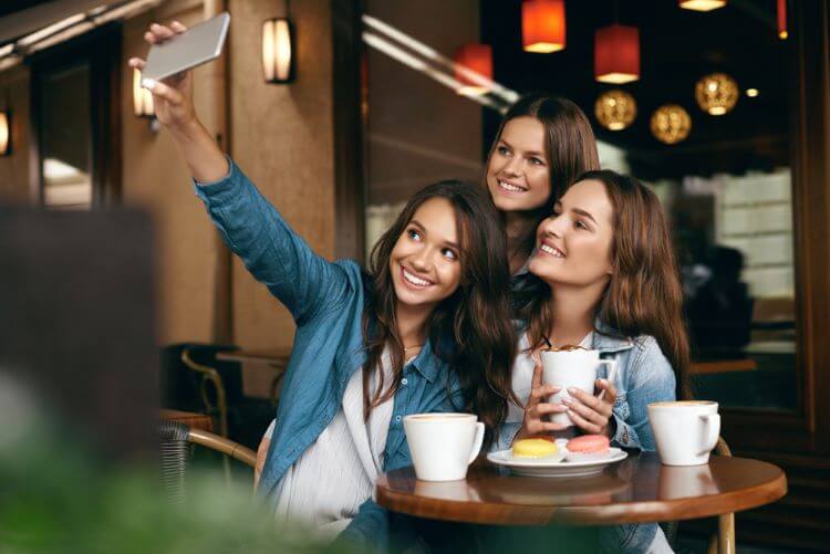 カフェで自撮りする女性3人