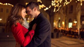 イルミネーションのなか身を寄せ合うカップル