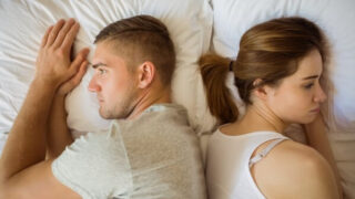 背中合わせで寝るカップル