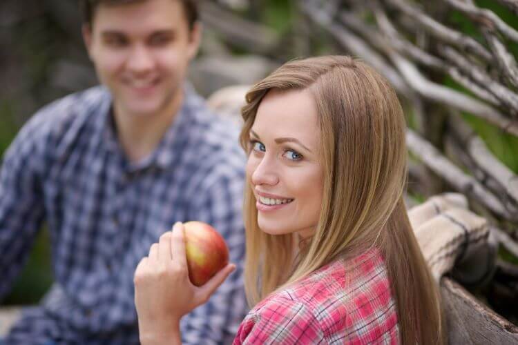 リンゴを持つ笑顔の女性