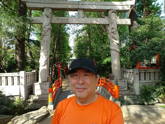馬橋稲荷神社の鳥居の前に立つ男性