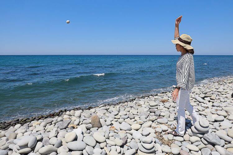 海に石を投げる女性